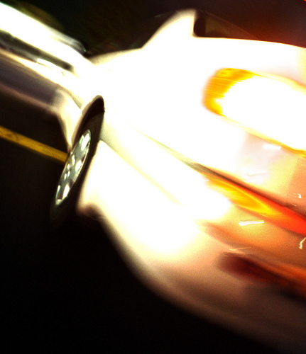 Car dissolving into orange and white motion blur at night