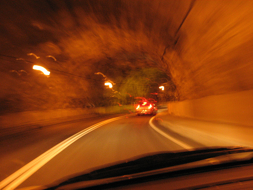 Blurred drive through an orange sodium-lit tunnel