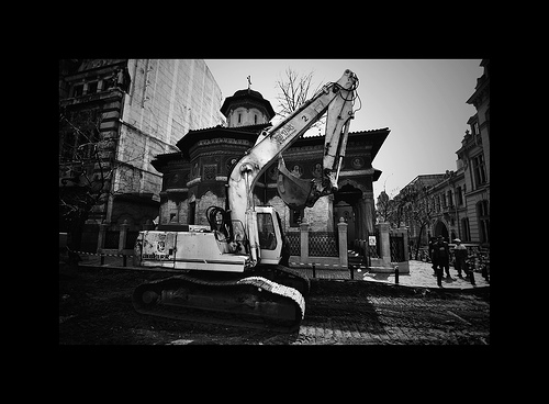 Excavator in front of an ornate church, black and white