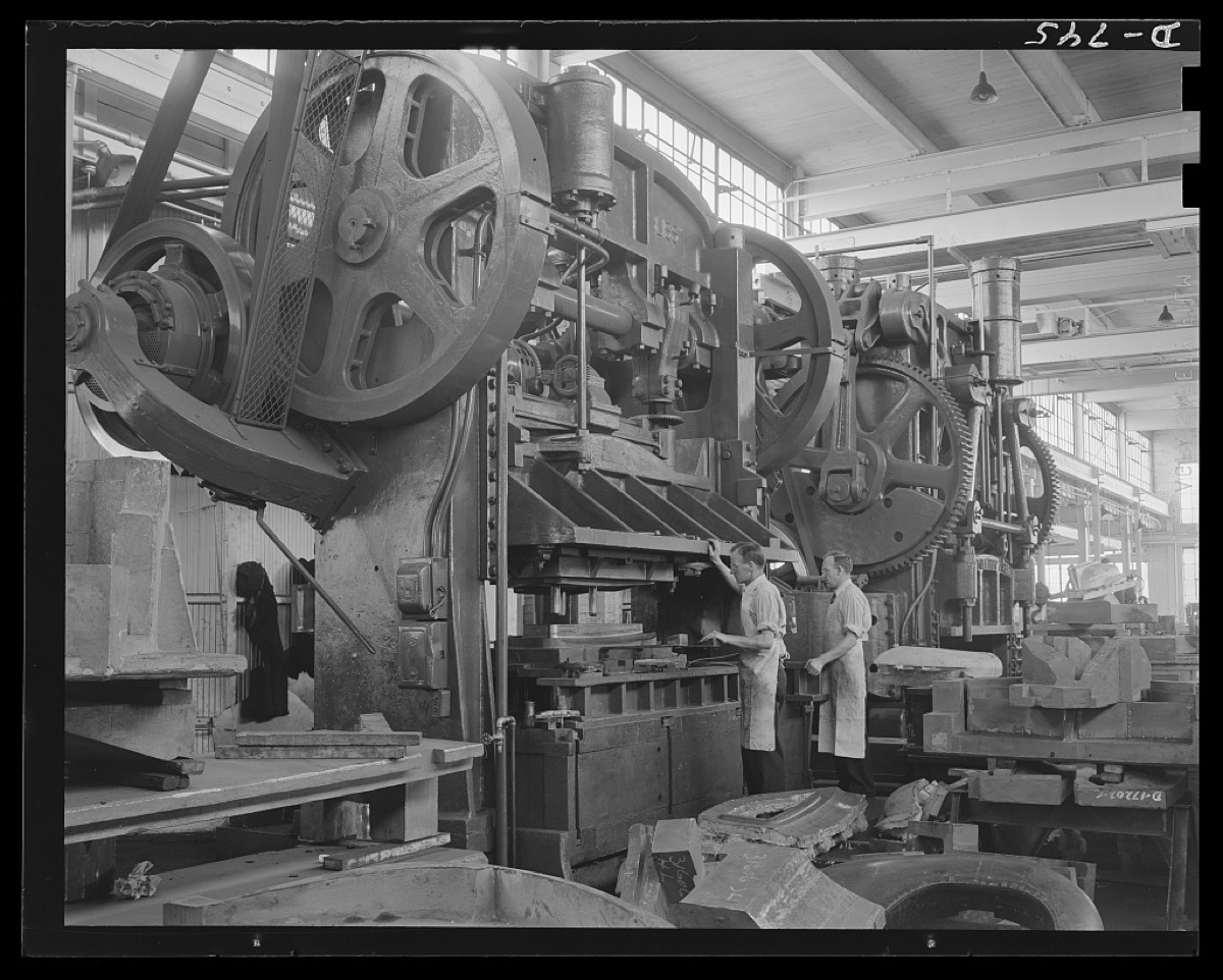 Workers at a giant forging press testing dies, 1940s
