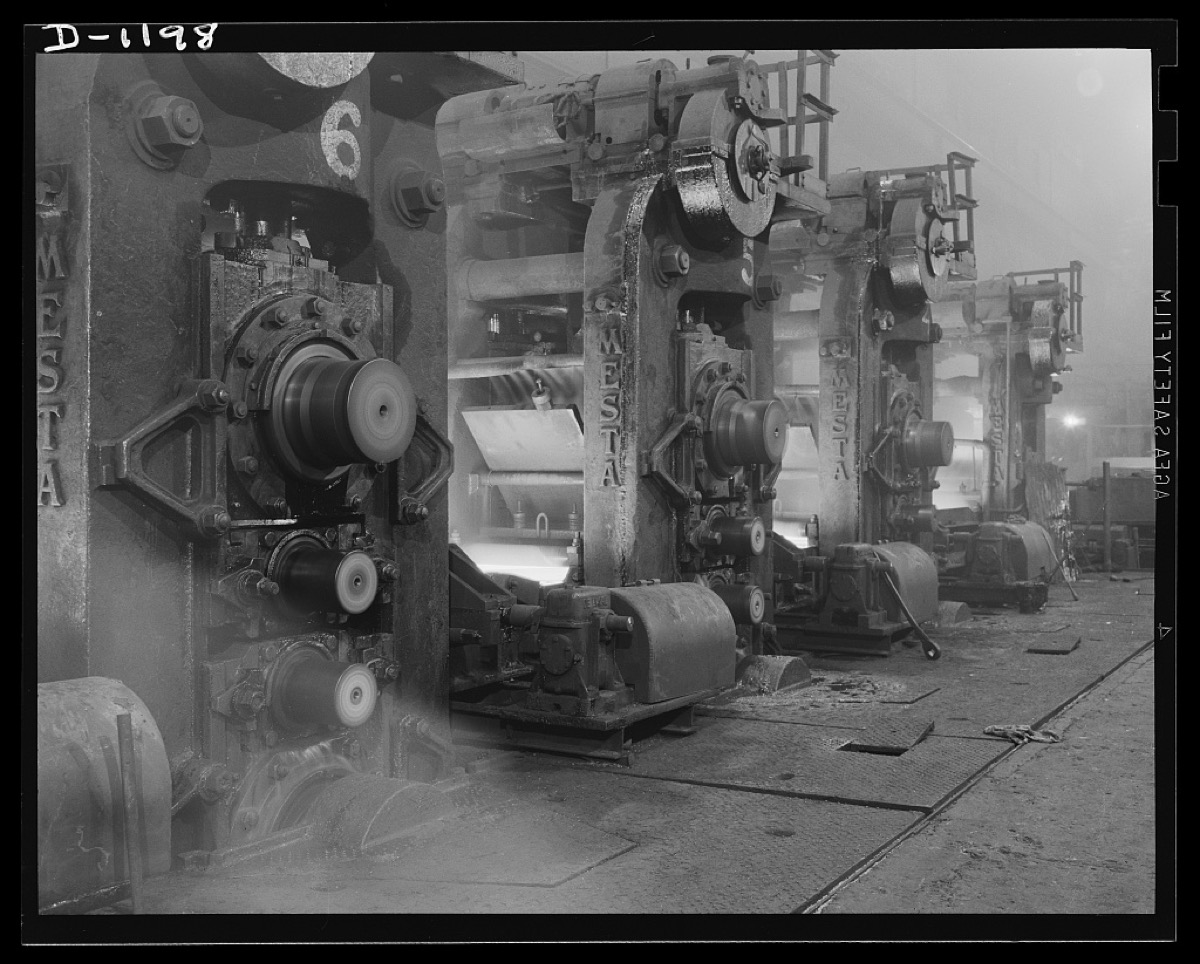 Row of rolling mill stands in steam, 1940s steel plant