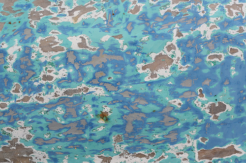 Blue and turquoise peeling paint on a ship hull
