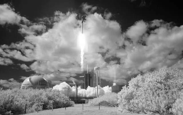 A rocket surrounded by large bright clouds at launch.